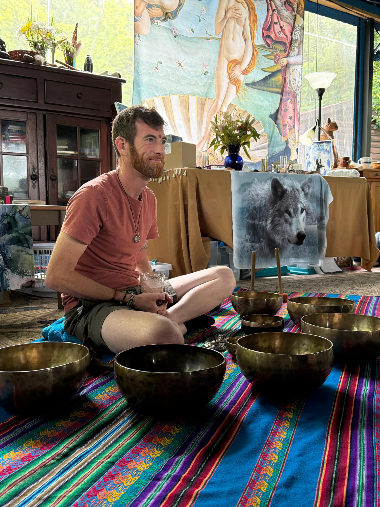 Bryan seated among his Tibetan singing bowls in his healing space